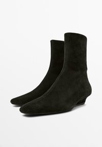 Coppia di stivaletti alla caviglia in camoscio nero con tacchi bassi a spillo e punte dritte, mostrati affiancati su sfondo bianco.