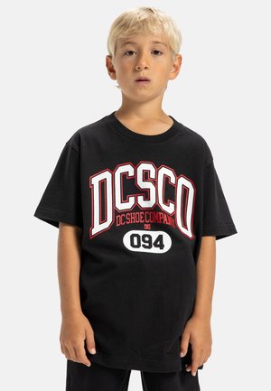 Schwarzes Baumwoll-T-Shirt mit kräftigem roten und weißen Grafiktext "DCSCO DC Shoe Company" und Zahlen. Kurze Ärmel, lockere Passform.