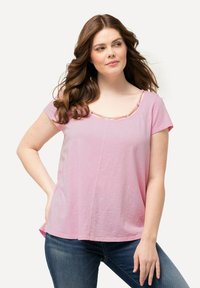 T-shirt rosa con maniche corte e scollatura rotonda, caratterizzato da un bordo a strisce a contrasto. Il tessuto sembra morbido con una vestibilità rilassata.