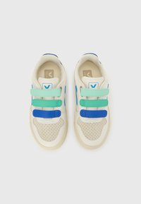 Sneakersy z kremową skórzaną cholewką, perforowanym noskiem i trzema regulowanymi paskami w kolorach niebieskim i zielonym. Posiadają beżową podeszwę z oznaczeniem marki.