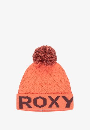 Orange stickad mössa med brun pom-pom och texten "ROXY" på den uppvikta kanten i feta bruna bokstäver.