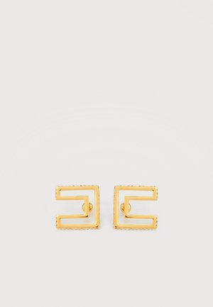 Paar kleine quadratische Ohrstecker aus goldfarbenem Metall mit ausgeschnittenem geometrischem Design auf hellem Hintergrund.