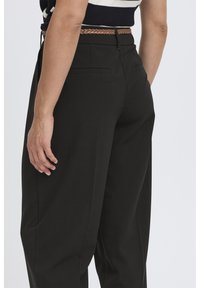 Black tailored trousers with a straight-leg design, featuring a smooth texture, back pockets, and paired with a braided belt in light brown.