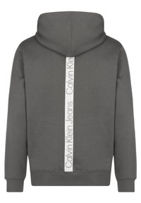Felpa con cappuccio grigia scura con una striscia bianca verticale sul retro che presenta il testo "Calvin Klein Jeans" in grigio chiaro.