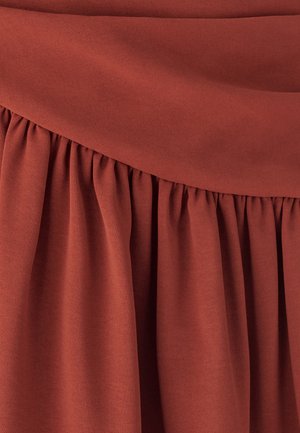 Tessuto color ruggine, caratterizzato da una texture liscia e un design arricciato in vita, che crea un aspetto fluido e morbido.