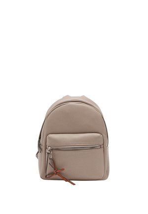 Beżowy skórzany plecak z przednią kieszenią na zamek błyskawiczny i brązową skórzaną zawieszką na suwaku, stojący pionowo na białym tle.