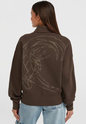 Bruine oversized sweatshirt met hoge kraag, voorzien van een gestructureerd grafisch ontwerp op de achterkant. Zacht materiaal met geribde manchetten en zoom.