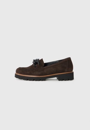 Brown suede loafer with a rounded toe, black leather bow accent, textured sole, and a contrasting beige stitching detail along the edge.