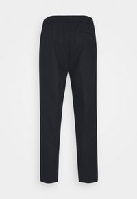 Sorte bukser med elastisk talje, tapered ben og en enkelt baglomme på højre side. Lavet af et glat stof.