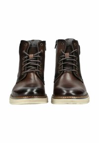 Botas de tobillo de cuero marrón con un acabado suave, con un diseño de cordones, dos ojales de metal y una suela blanca contrastante.