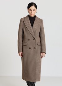 Cappotto doppiopetto marrone a quadri houndstooth con ampi revers, tasche laterali e bottoni marroni. Tessuto strutturato con silhouette dritta.
