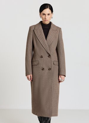 Cappotto doppiopetto marrone a quadri houndstooth con ampi revers, tasche laterali e bottoni marroni. Tessuto strutturato con silhouette dritta.
