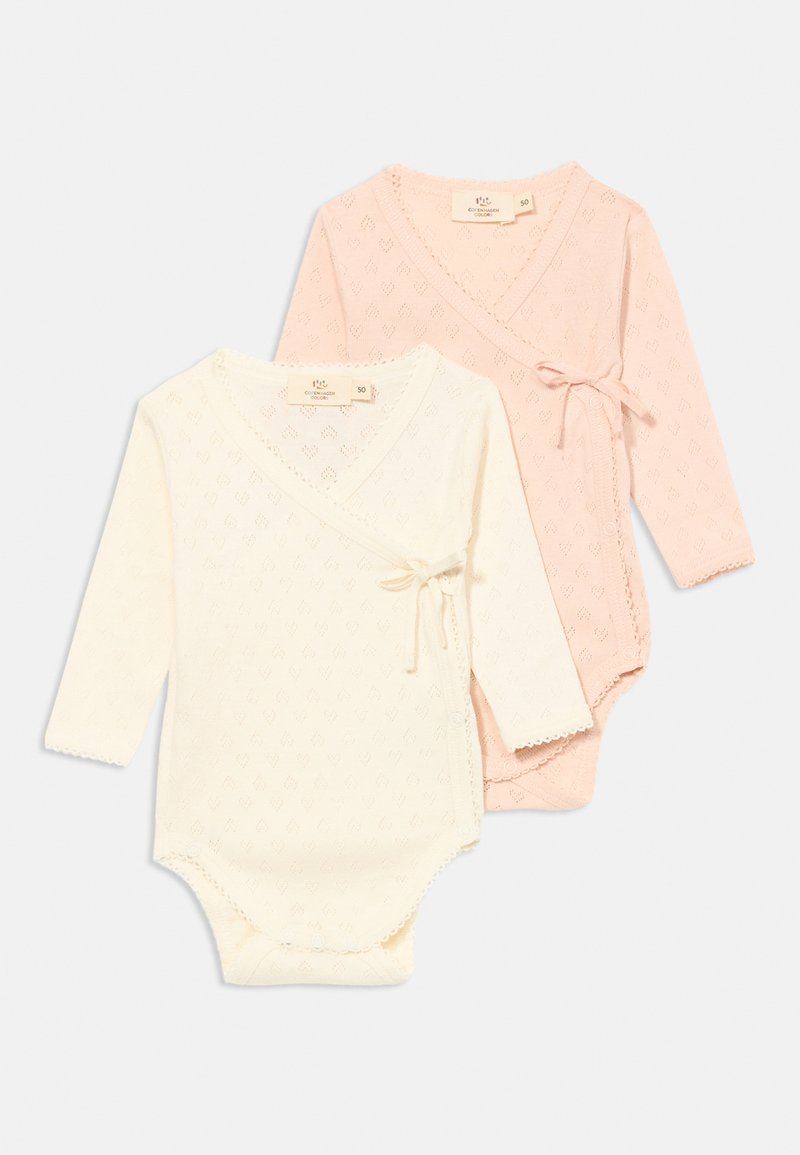 Dois bodies de bebé de manga longa: um em creme e outro em rosa suave, com textura em padrão de diamante, design envolvente e laços decorativos na cintura.