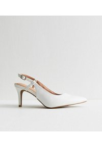 Pump bianco con cinturino posteriore, punta affusolata, parte superiore in pelle e piccola fibbia regolabile. Caratterizzato da un tacco di 7,5 cm e una soletta di colore beige chiaro.