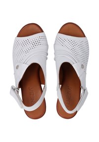 Weiße Sandalen mit perforiertem Lederoberteil, offenes Zehen-Design, verstellbarer Knöchelriemen und brauner Innensohle. Bemerkenswerte Steppdetails.