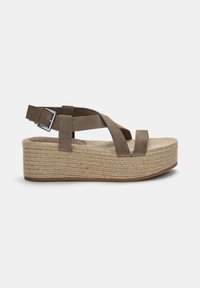 Braune Wildleder-Plateausandalen mit überkreuzten Riemen. Jutebezogene Sohle mit runder Zehenpartie. Verstellbarer Schnallenverschluss am Knöchelriemen.