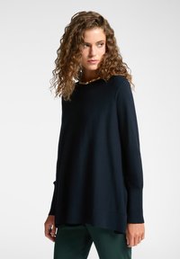 Marineblauwe trui met lange mouwen, ronde hals, een relaxed fit en ribbelstructuur bij de manchetten en de zoom. Gladde textuur en zachte stof.