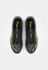 Black soccer shoes with neon yellow accents, featuring a streamlined design, a textured upper, and a lace-up closure. Model name: F50.