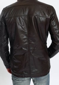 Braune Lederjacke mit glatter Textur, geradem Schnitt, horizontalen Nahtdetails und minimalistischem Design.