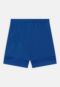 Shorts deportivos azules lisos con cinturilla elástica y detalles de malla cerca del dobladillo sobre un fondo blanco.