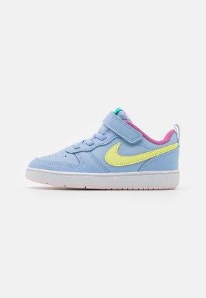 Child's light blue Nike sneaker with neon yellow swoosh, pink inner lining, white sole, and Velcro strap on a white background.