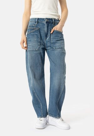 Lys blå denim jeans med en avslappet passform, med flere frontlommer og en falmet finish. Brukt med hvite sneakers.