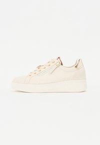Beige lærersneaker med teksturert overflate, gullfarget hardware og plattform såle. Har en sidelukking og dekorative snøringer.