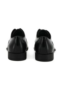 Scarpe in pelle nera con finitura liscia, profilo basso e punta arrotondata. Presentano una suola in gomma piatta e dettagli di cucitura sottili sul retro.