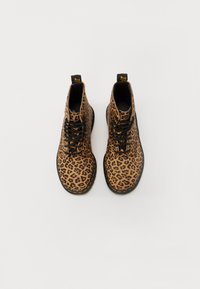 Ankle čizme s leopard uzorkom, mekog teksturnog vanjskog dijela, crnim vezicama, žutim šavovima i uzorkom na neutralnoj pozadini.