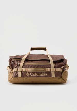 Καφέ και ταμπά Duffel τσάντα Columbia με μπεζ χειρολαβές, μπροστινή τσέπη με φερμουάρ και ρυθμιζόμενους πλάγιους ιμάντες σε απλό λευκό φόντο.