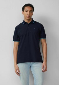 Navy polo shirt with short sleeves, contrasting teal collar and sleeve trims, and a small logo on the left chest. Cotton fabric.