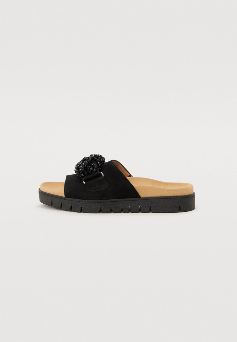 Sandale negre din suede cu alunecare, prezentând o floare decorativă din mărgele, o talpă interioară bej căptușită și o talpă exterioară din cauciuc texturat negru.