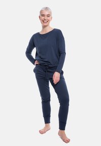 Navy blue loungewear set featuring a long-sleeve top with a relaxed fit and drawstring waist pants, made from soft, stretchy material.