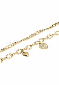 Guldtonad lagd kedjeband med en oregelbunden kedjedesign. Innehåller två hjärtformade berlocker, en polerad och en med kristallaccenter.