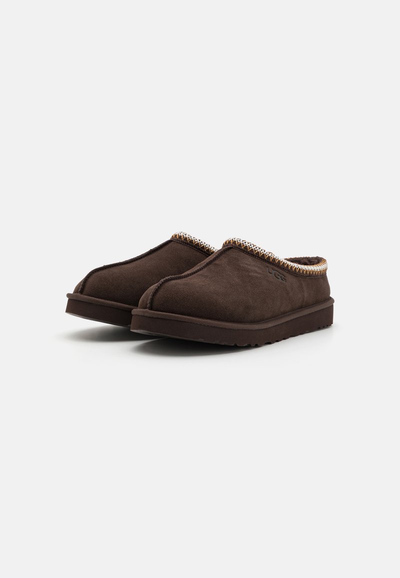 Bruine suède instappantoffels met een gestructureerde, contrasterende rand langs de bovenrand, een lichte rubberen zool en een minimalistisch ontwerp.