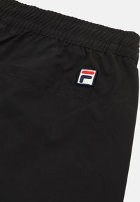 Zwarte sportshorts met een elastische tailleband. Voorzien van een klein, meerkleurig FILA-logo geborduurd op de achterzak. Glad van textuur.