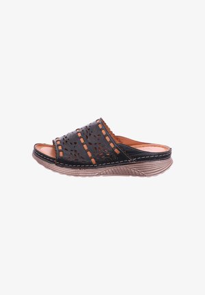 Black leather slip-on sandal with decorative cutouts, tan stitching, and a textured beige sole viewed from the side.