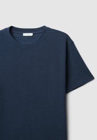 T-shirt a maniche corte blu navy con tessuto testurizzato, scollatura a girocollo e vestibilità comoda. Etichetta del marchio visibile vicino al collo.