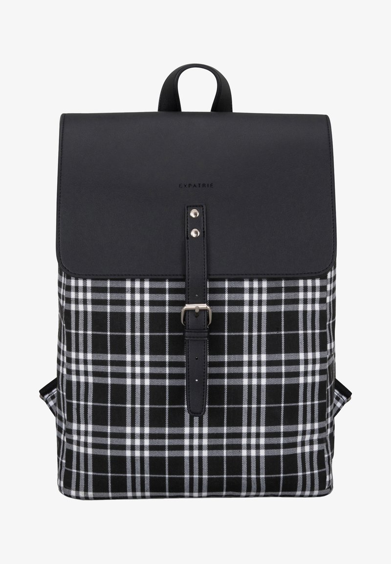 Black and white plaid fabric backpack with a leather flap, buckle closure, and a top handle. Features adjustable shoulder straps.