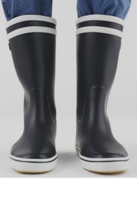 Svarta gummistövlar med vita horisontella ränder längst upp, mönstrade sulor och en slät yta. Designade för vattenavvisning.