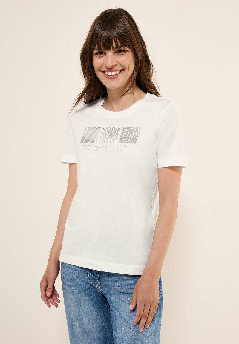 T-shirt en coton blanc à manches courtes et col rond. Présente un design graphique gris sur le devant avec le texte "élargir les horizons."