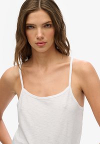 Witte katoenen tanktop met dunne bandjes, met een ronde halslijn en een gladde, lichte textuur. Eenvoudig en ongecompliceerd ontwerp.