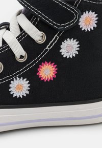 Czarne wysokie buty na płaskiej podeszwie z białymi sznurowadłami i rzepem. Ozdobione kolorowym haftem kwiatowym: różowe, białe i pomarańczowe kwiaty.