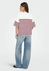 Gestreepte t-shirt met maroon en witte horizontale strepen, korte mouwen, gecombineerd met lichtblauwe wijdnekkige jeans met een relaxte pasvorm.