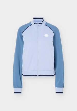 Hele sinine lukuga jope tumedamate siniste raglaanmuhvidega, püstkraega ning tumesiniste triipudega mansettidel ja alumisel äärel.