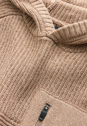 Kootud beež kapuutsiga pusa, millel on tekstuuriga muster, pool-zipperiga sulgemine ja eesmine tasku metallist tõmblukuga.