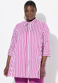 Camicia a righe rosa e bianche con colletto, chiusura a bottoni e maniche a tre quarti. Tessuto leggero con un fit leggermente rilassato.