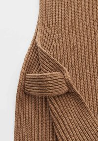 Brauner gerippter Strickpullover mit einer dicken Textur und einer umgeschlagenen Ärmel-Details. Der Stoff hat ein weiches, dickes Aussehen mit vertikalen Linien.