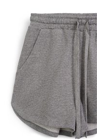 Pantaloni corti in cotone grigio con vita elasticizzata, cordoncino e tasche laterali. Texture morbida e dettaglio dell'orlo arrotondato.