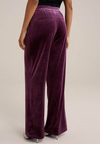 Paarse fluwelen wijde broek met een gestructureerde afwerking, voorzien van een rekbare tailleband en een achterzakdetail.